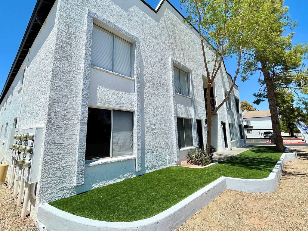 a white brick building with a grassy area in front of it