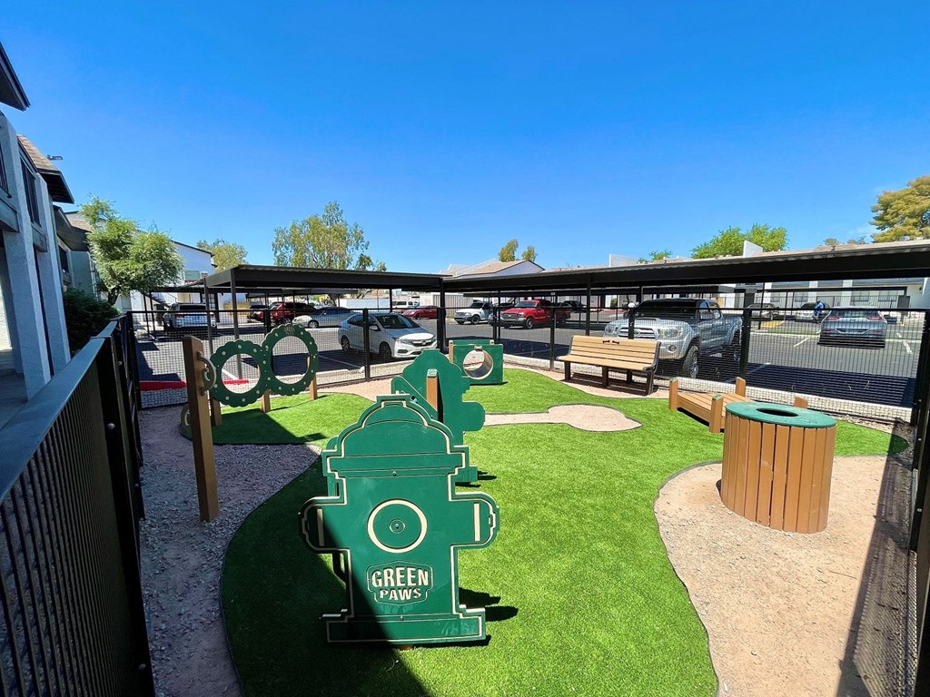 a park with a green fire hydrant in the middle of a grassy area