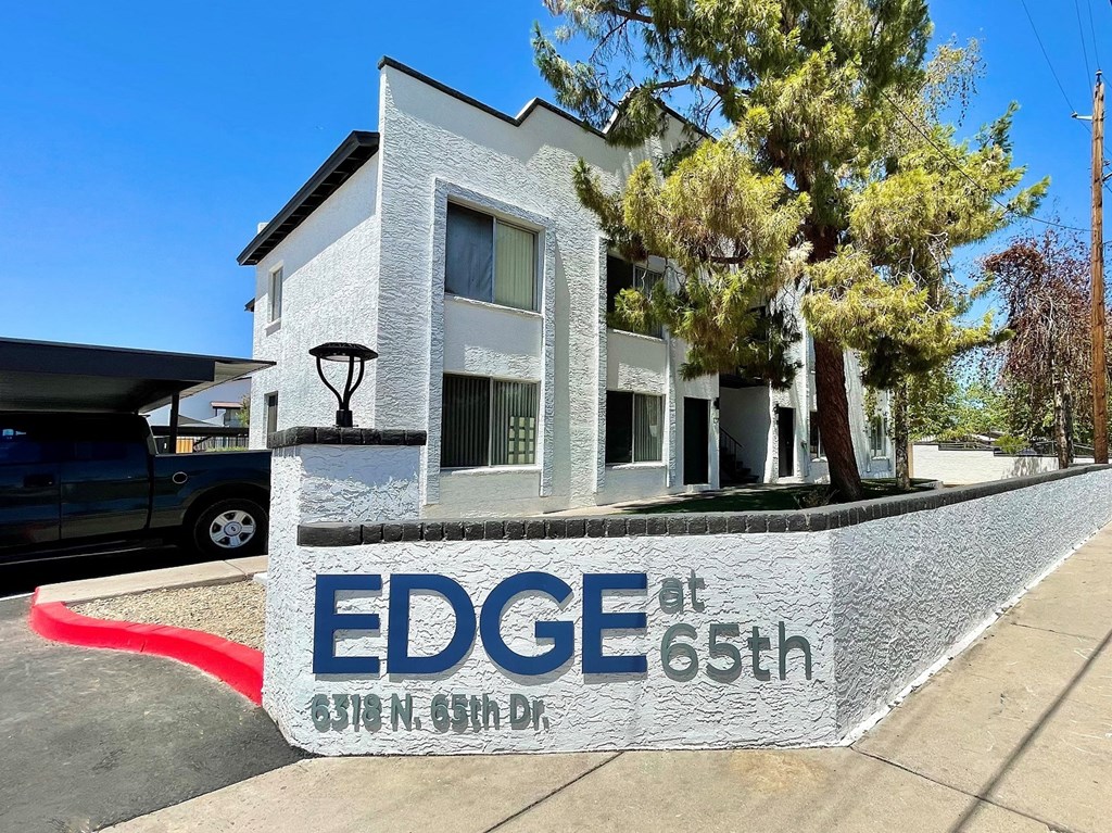 a sign that says edge at 65th in front of a house