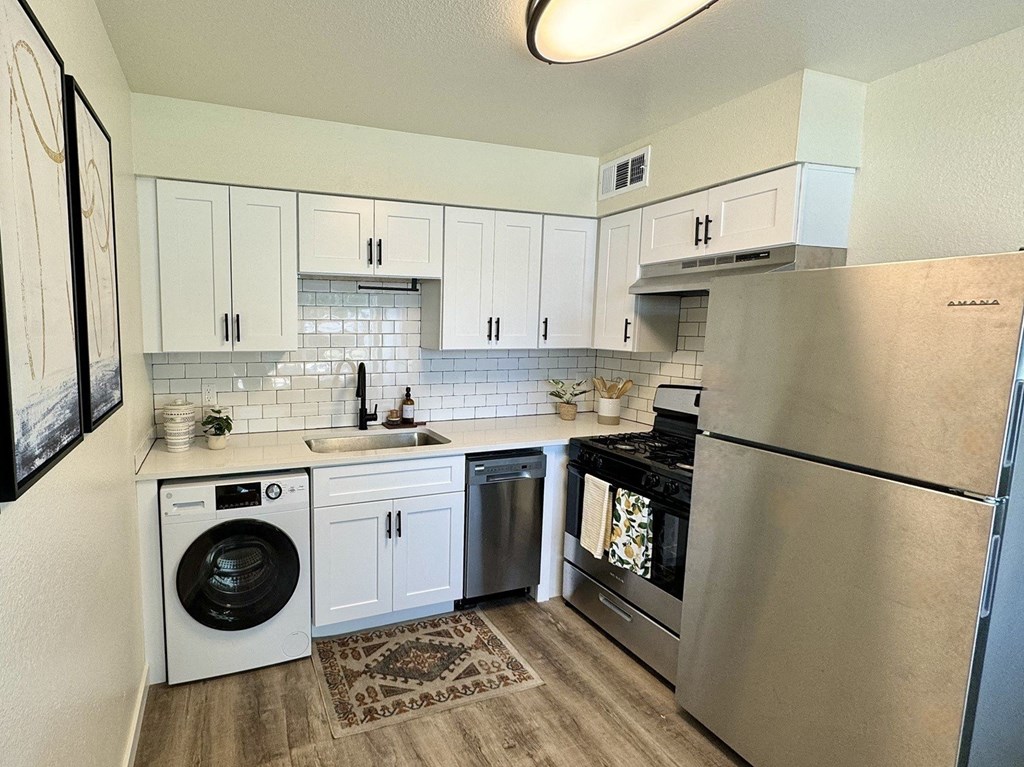 a kitchen with stainless steel appliances and white cabinets