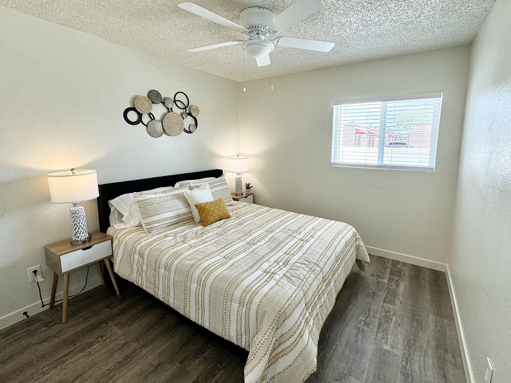 a bedroom with a bed and a ceiling fan