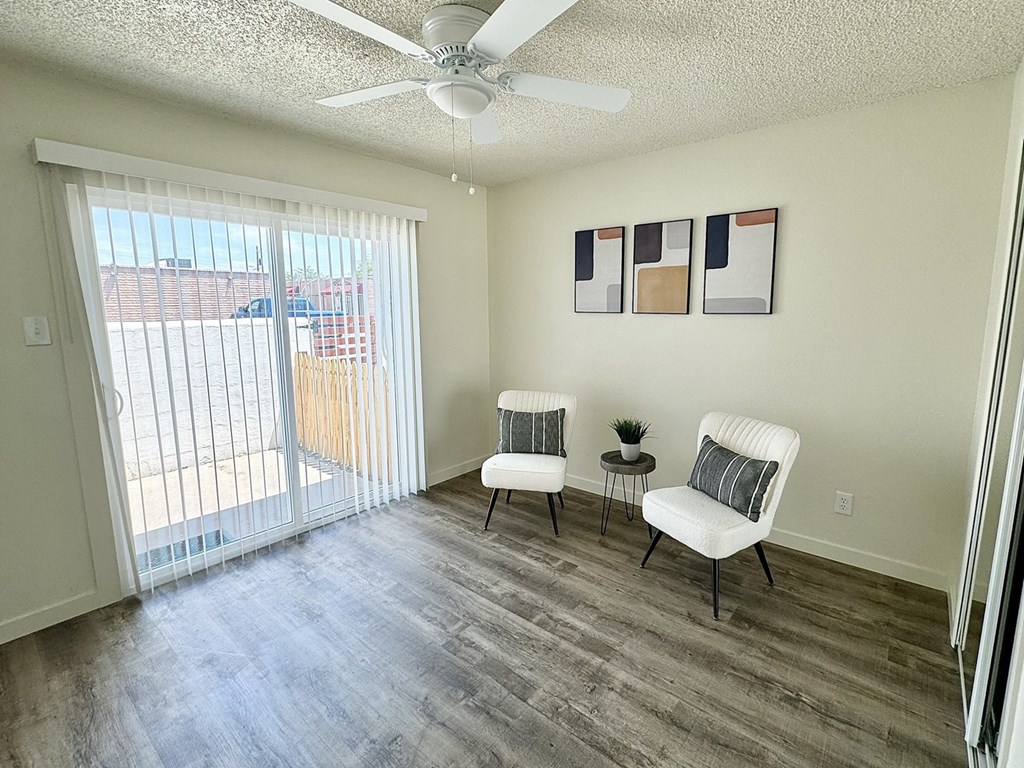 a living room with two chairs and a ceiling fan