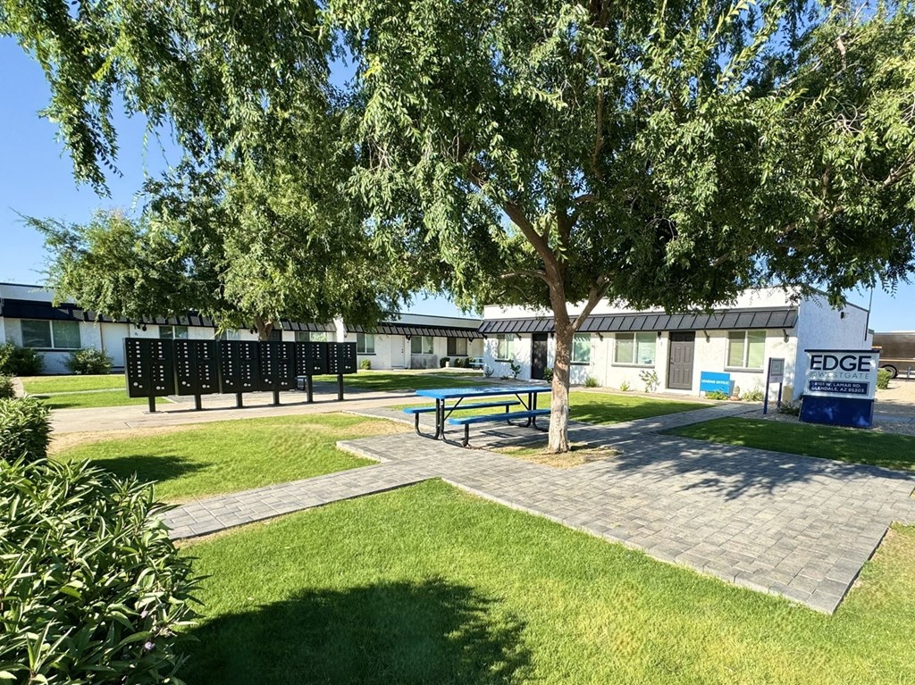 a picnic area with a tree in front of a building
