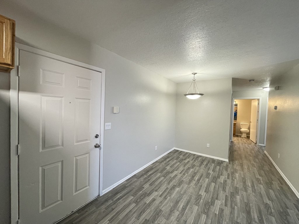 an empty living room and hallway with a white door
