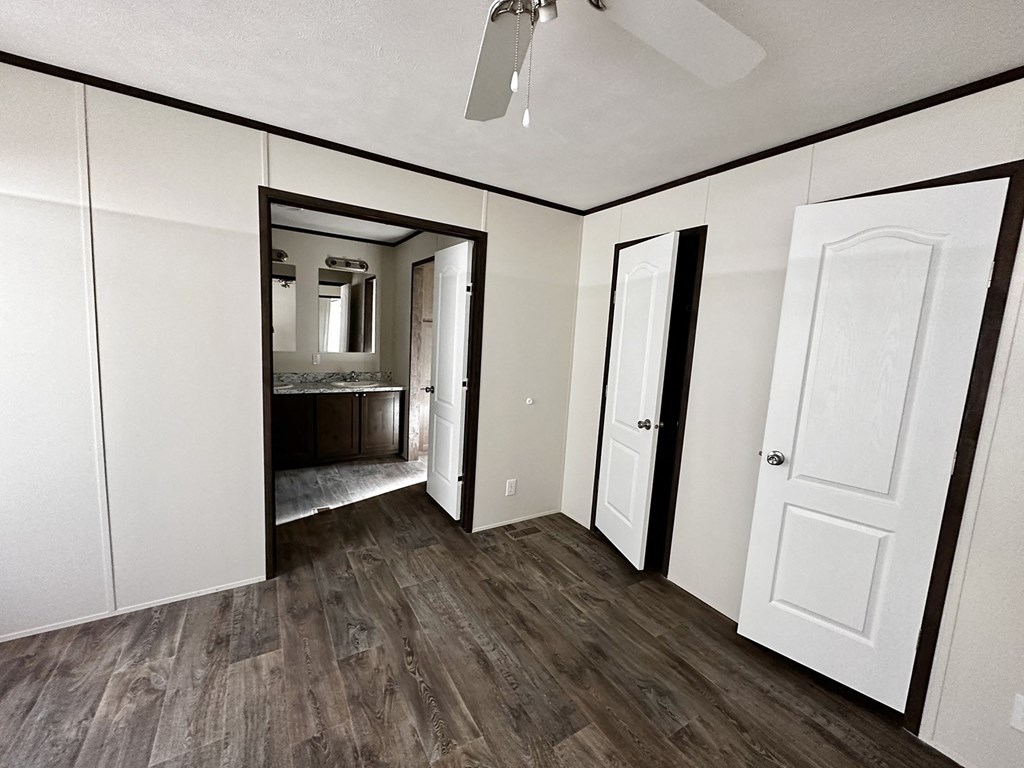 an empty room with white cabinets and a door to a bathroom