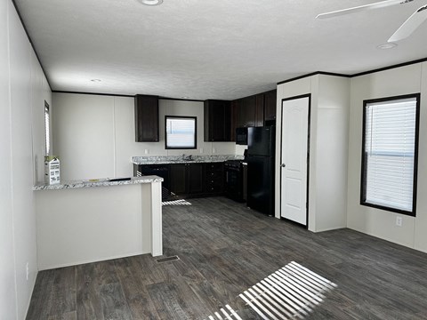 a view of a kitchen and a living room with wood floors