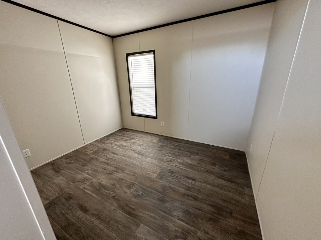 an empty room with white walls and a window