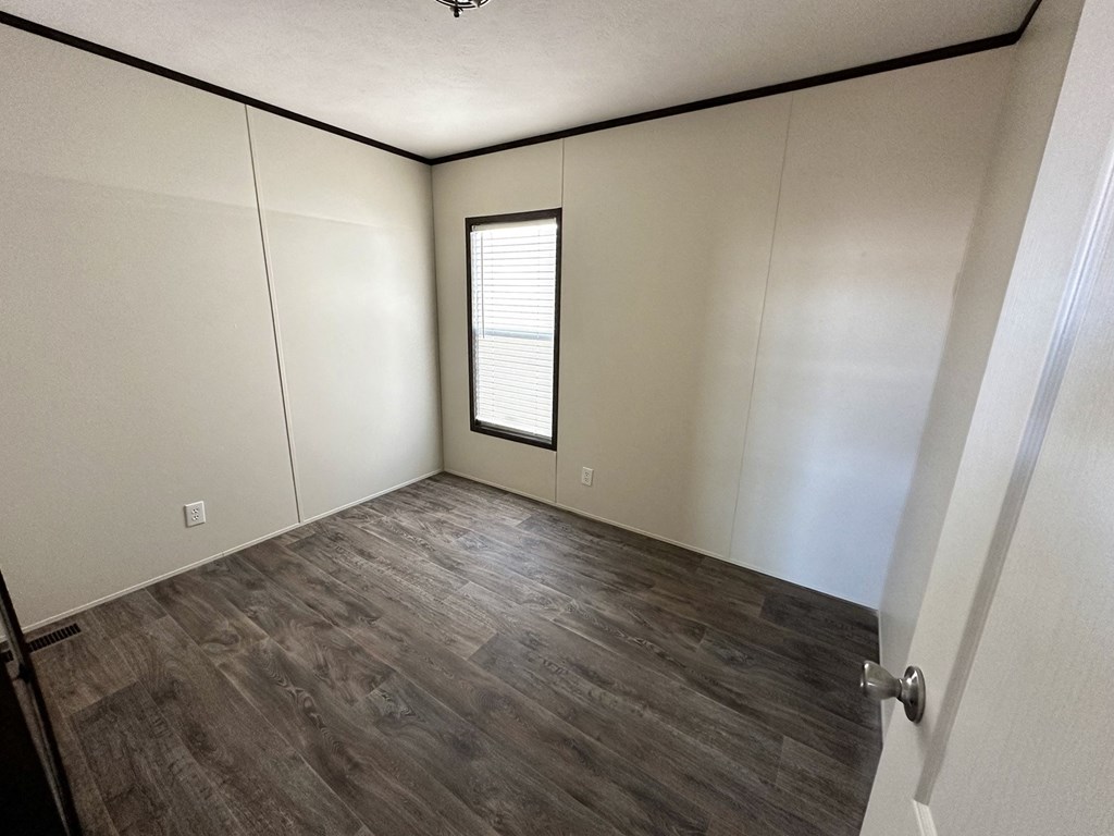 an empty room with white walls and a window