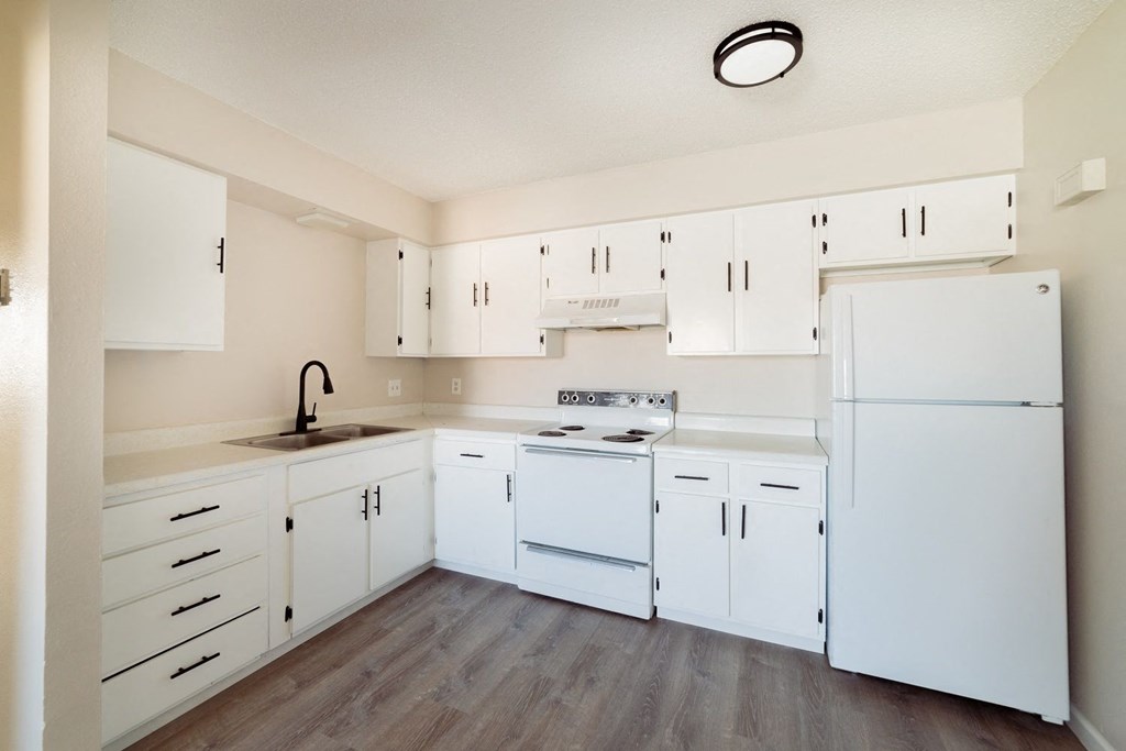 a white kitchen with white appliances and white cabinets