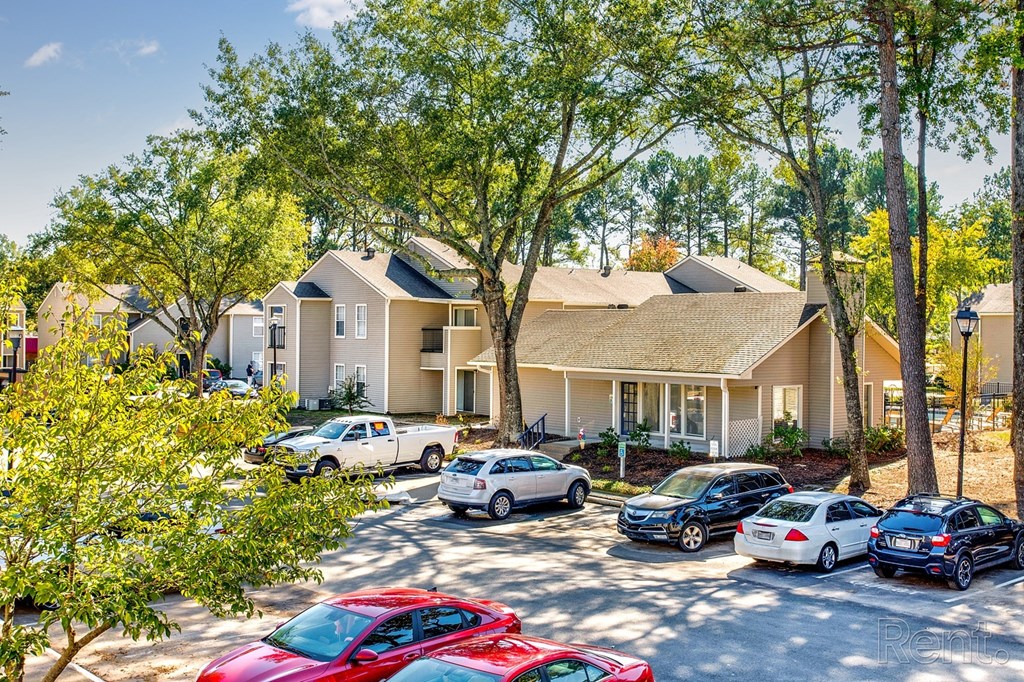 a parking lot with cars in front of houses