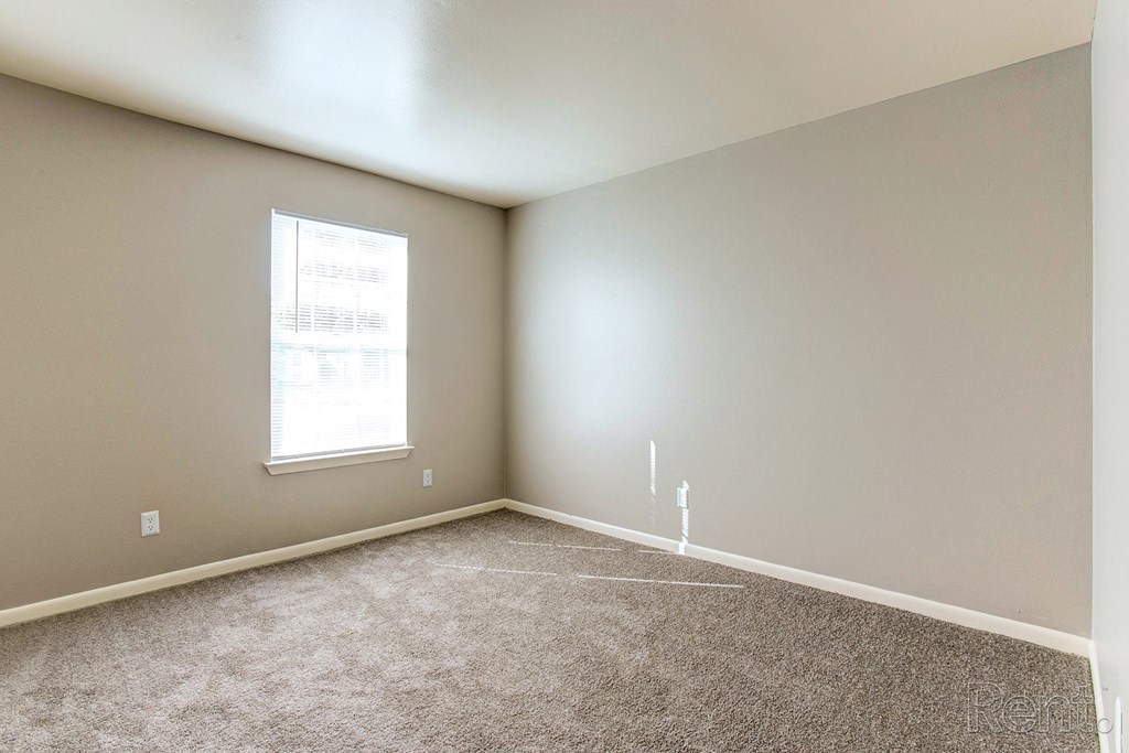 an empty room with carpet and a window
