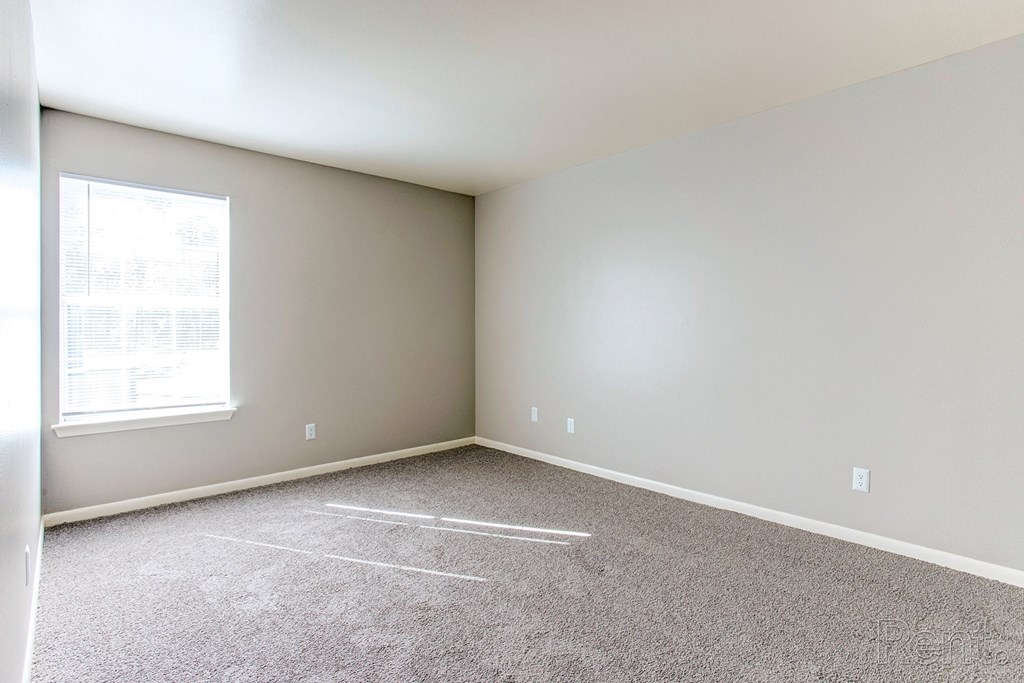 an empty room with carpet and a window