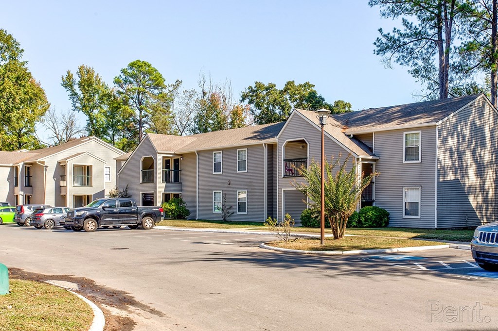 a row of apartment buildings with cars parked in front of them