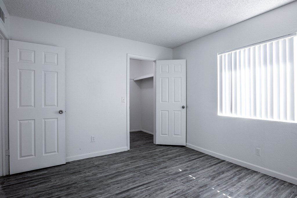 an empty living room with two doors and a window