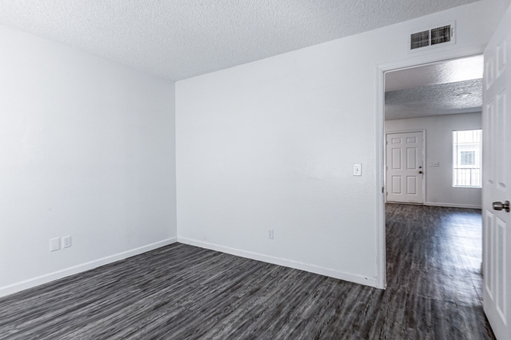 an empty living room with white walls and wood flooring