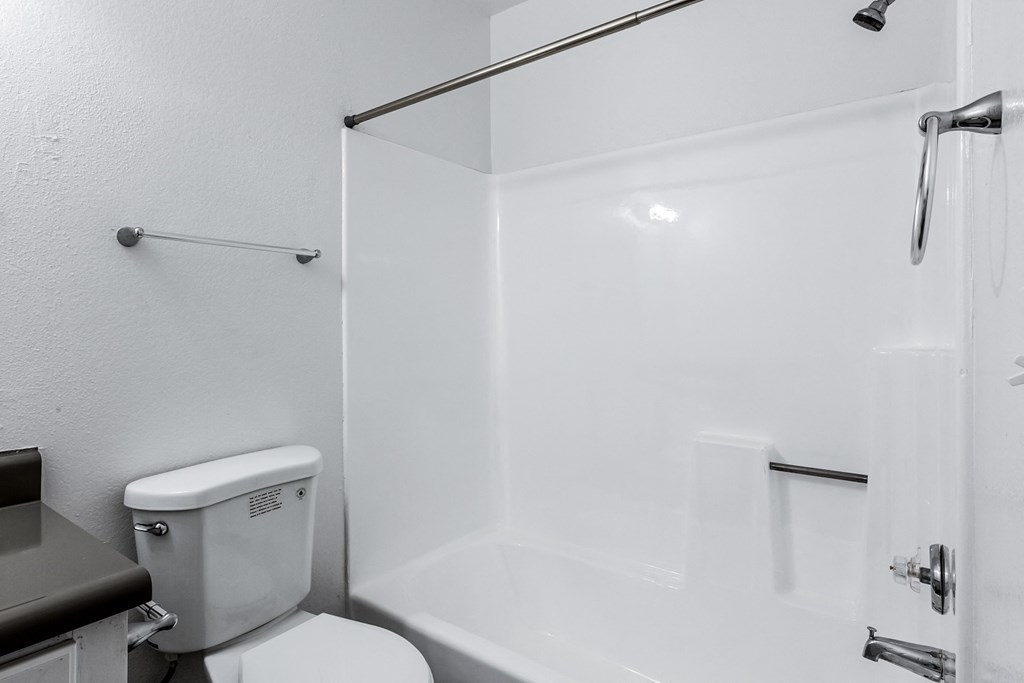a white bathroom with a shower and a toilet
