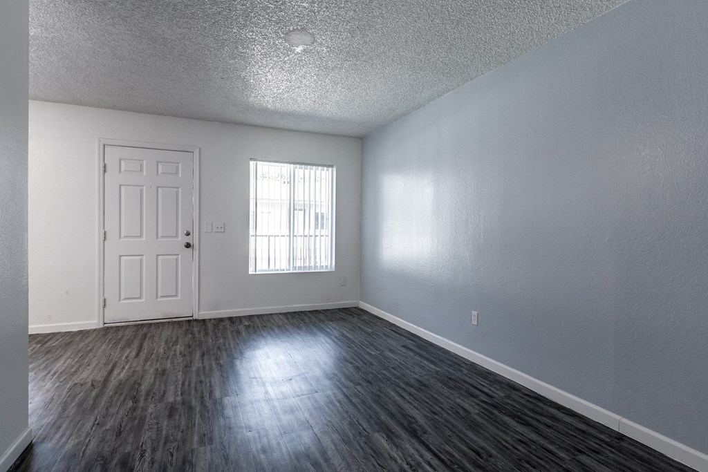 an empty living room with white walls and a white door