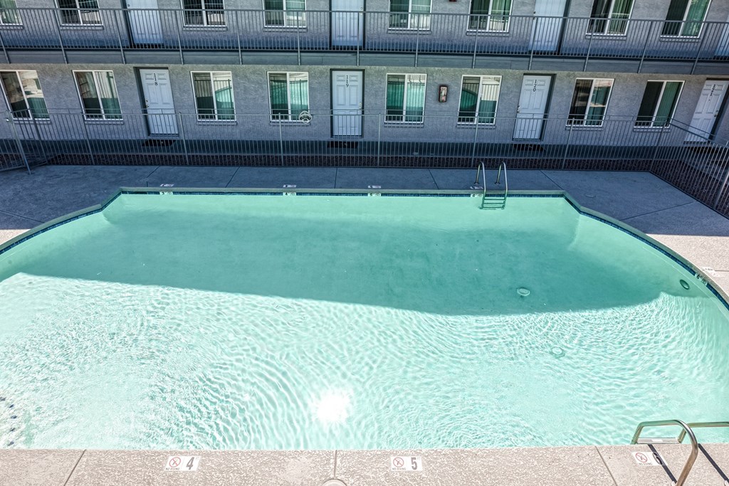 an empty swimming pool in front of an apartment building