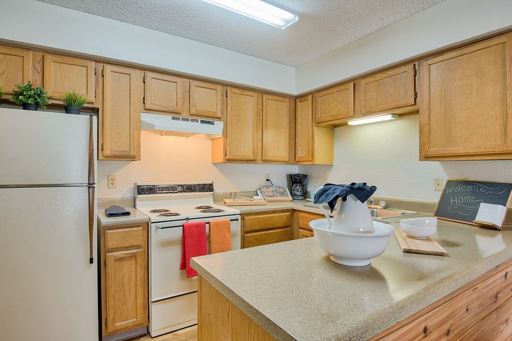 a kitchen with white appliances and wooden cabinets