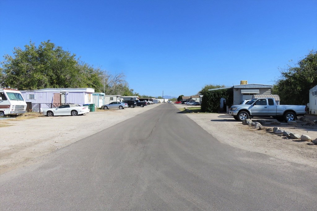 a long dirt road with trailers and cars parked on the side of it