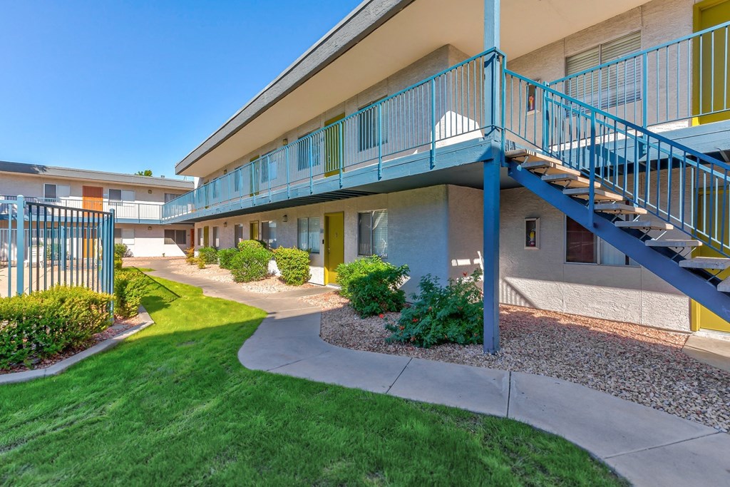 a building with a staircase and a yard in front of it