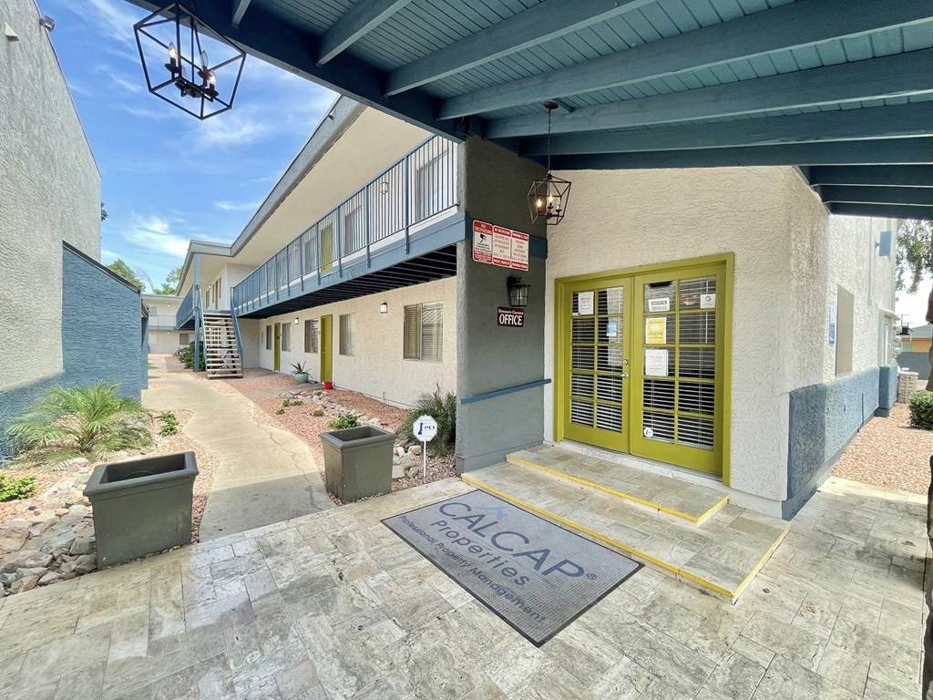a building with a yellow door and a sidewalk in front of it