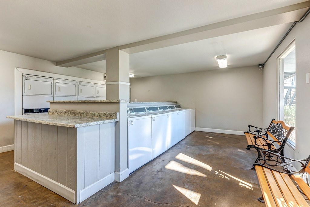 a kitchen with white cabinets and a counter top with a bench