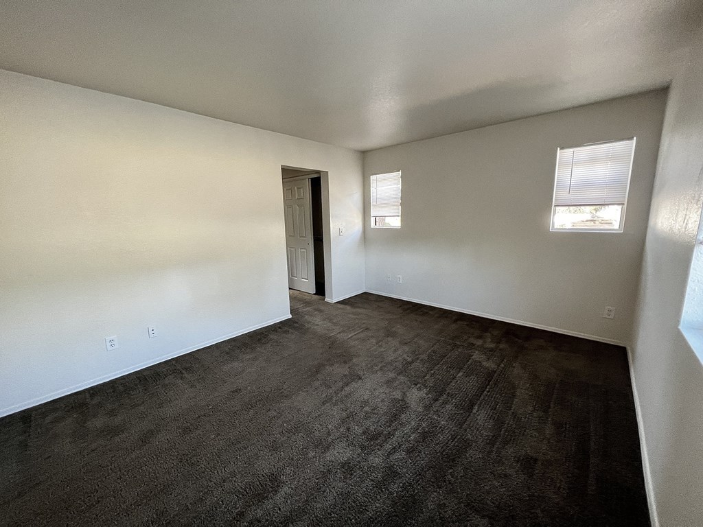 an empty living room with wood flooring and white walls