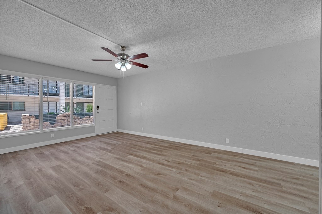 an empty bedroom with a ceiling fan