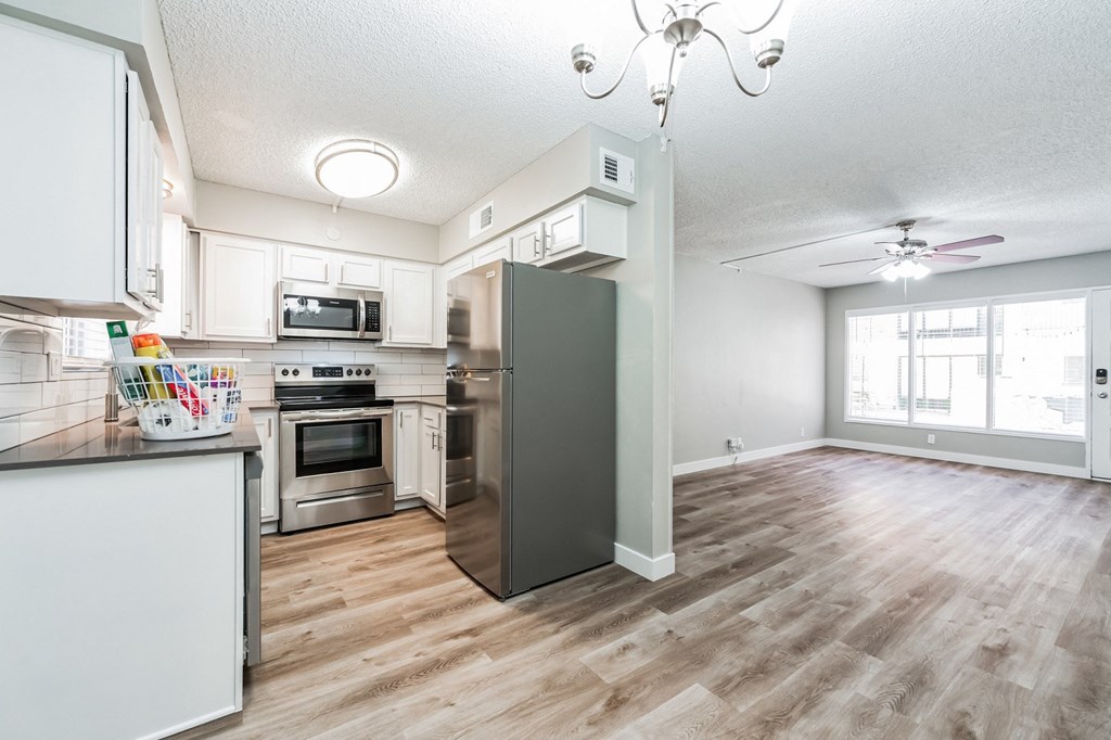 a kitchen and living room with hardwood floors and a large window