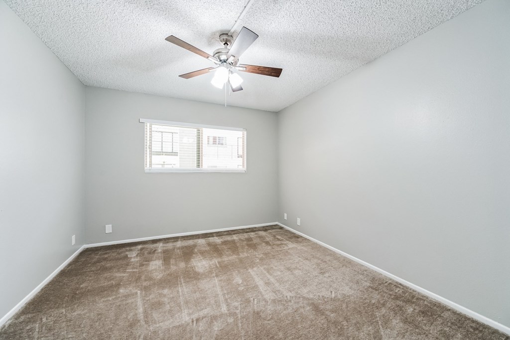 a large empty room with a ceiling fan