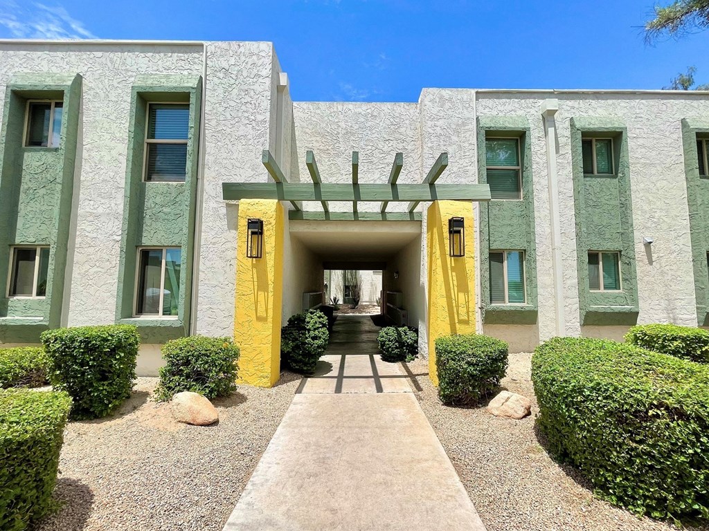a building with two yellow pillars and a green facade