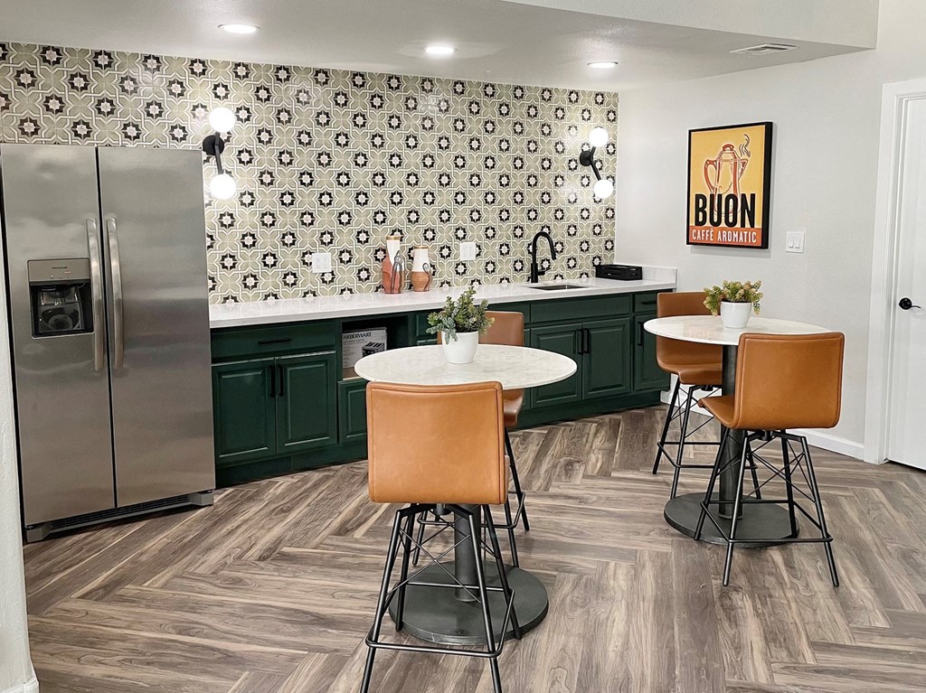 a kitchen with green cabinets and a stainless steel refrigerator