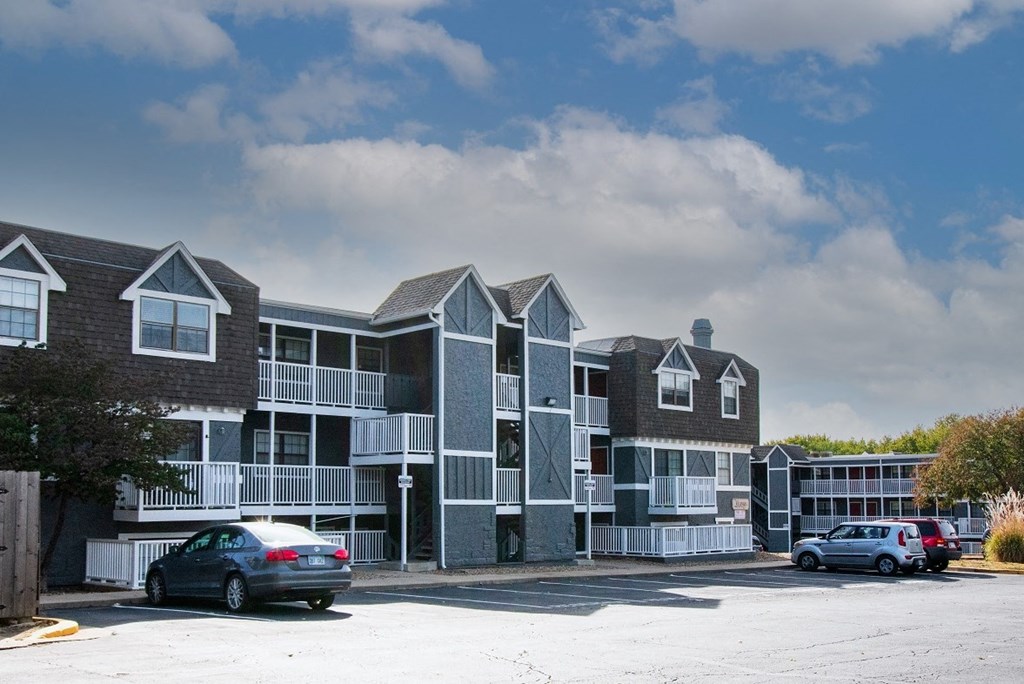 a large apartment complex with a parking lot in front of it