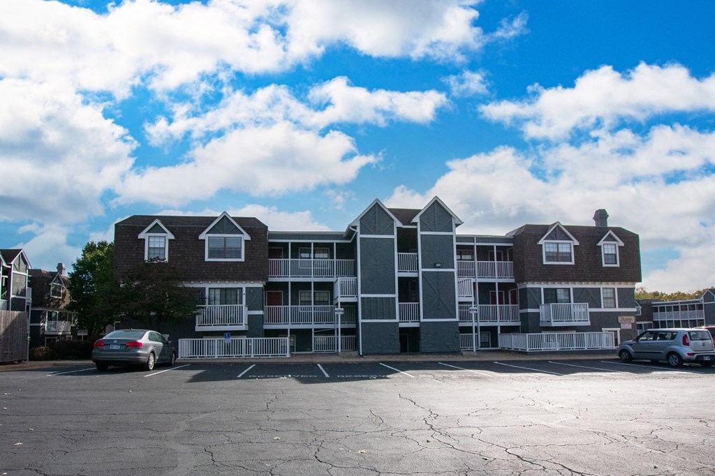 a large apartment building with a parking lot in front of it