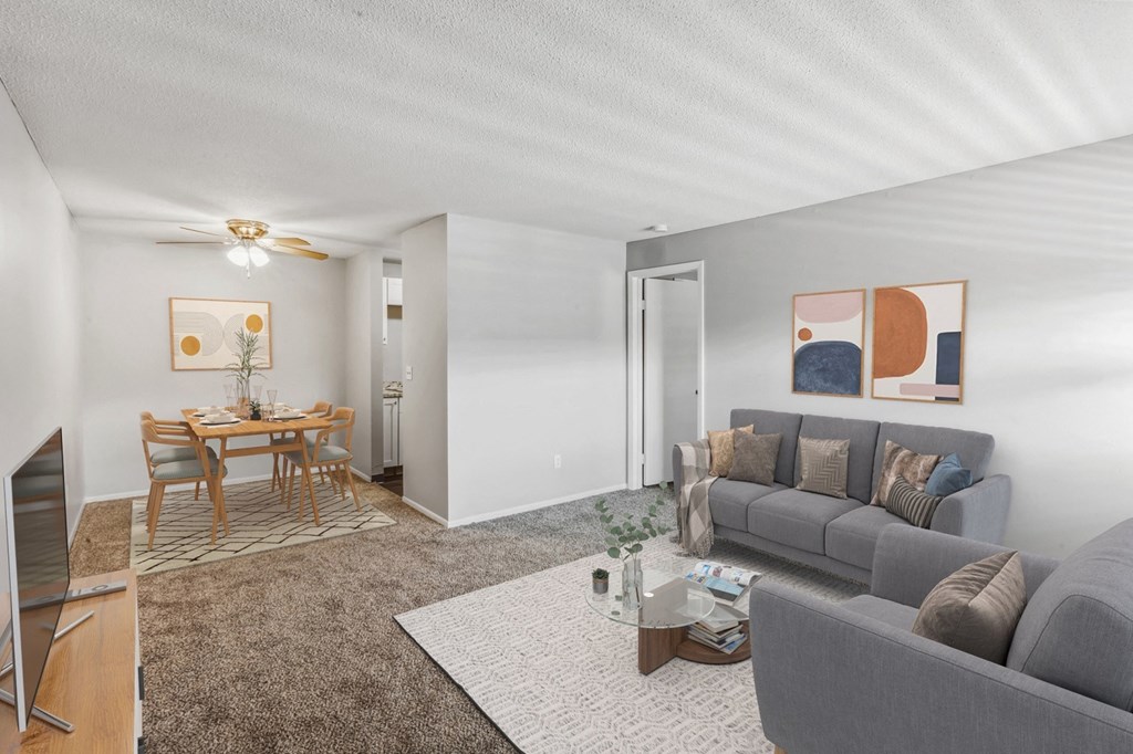 a living room with a couch a table and a ceiling fan