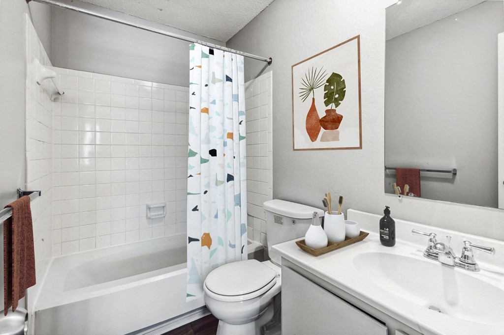 a bathroom with a white toilet next to a bath tub