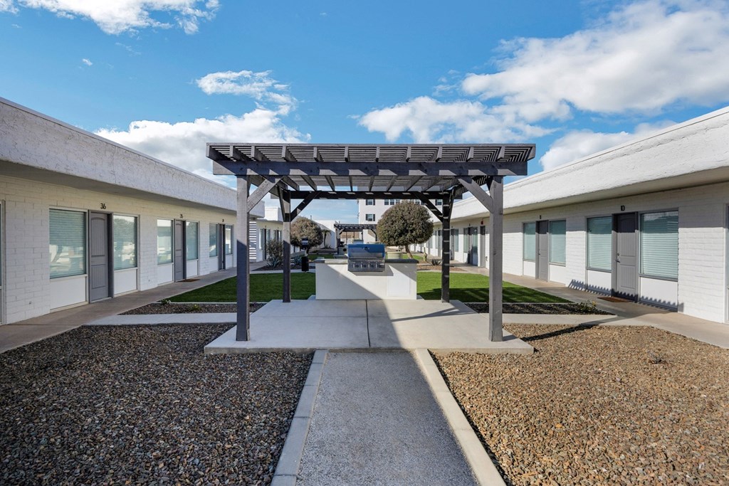 a courtyard with awnings and a bench in the middle