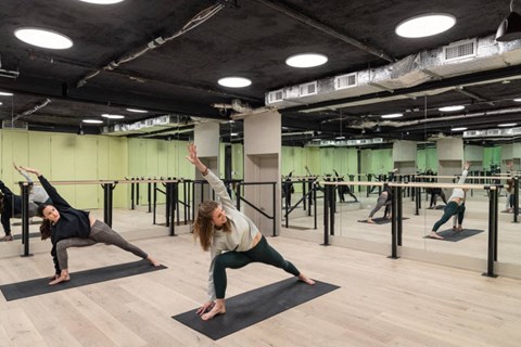 a group of people doing yoga in a gym