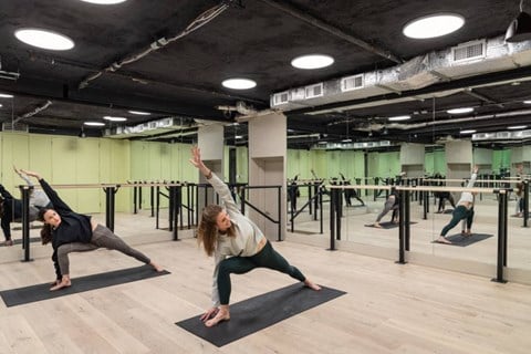 a group of people doing yoga in a gym
