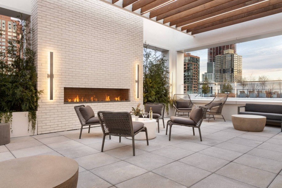 a terrace with a fireplace and tables and chairs