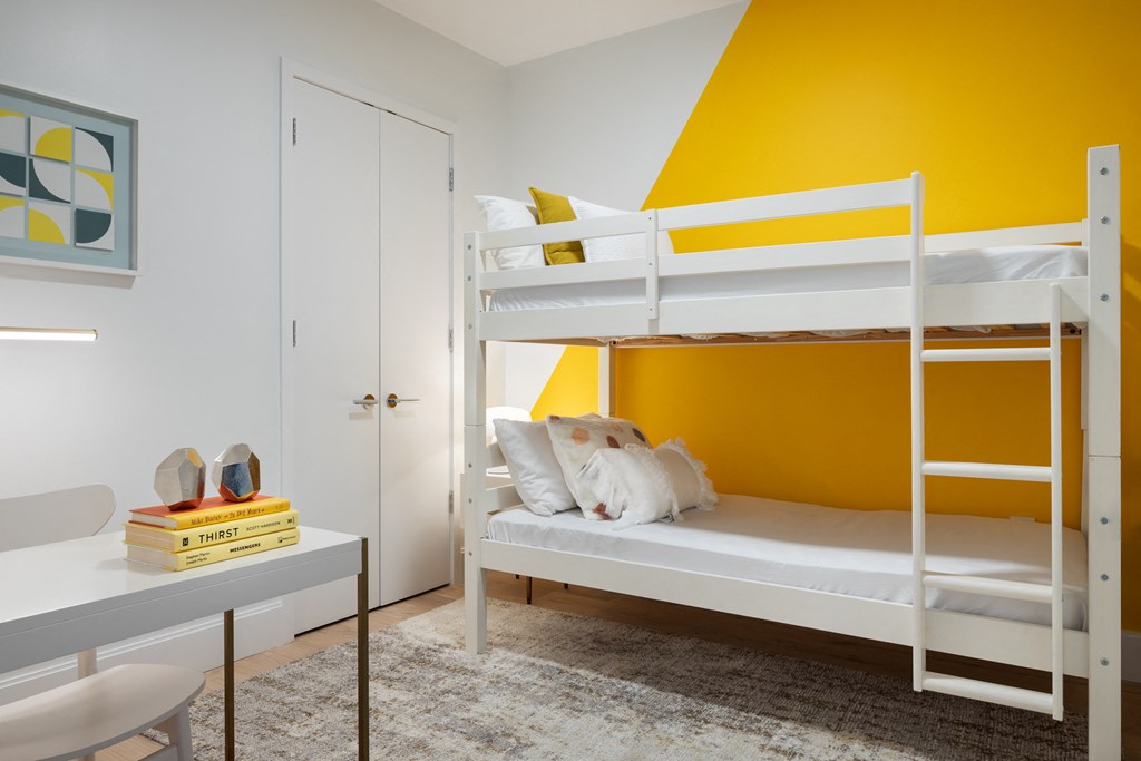 a bedroom with bunk beds and a yellow wall