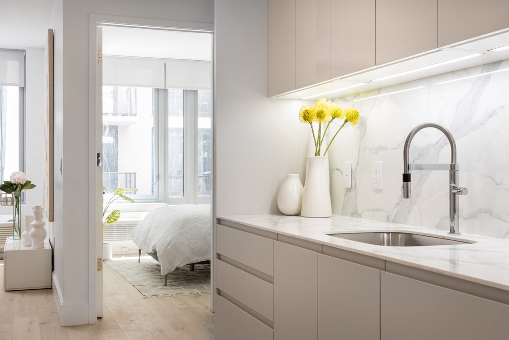 a kitchen with white cabinets and a sink and a window