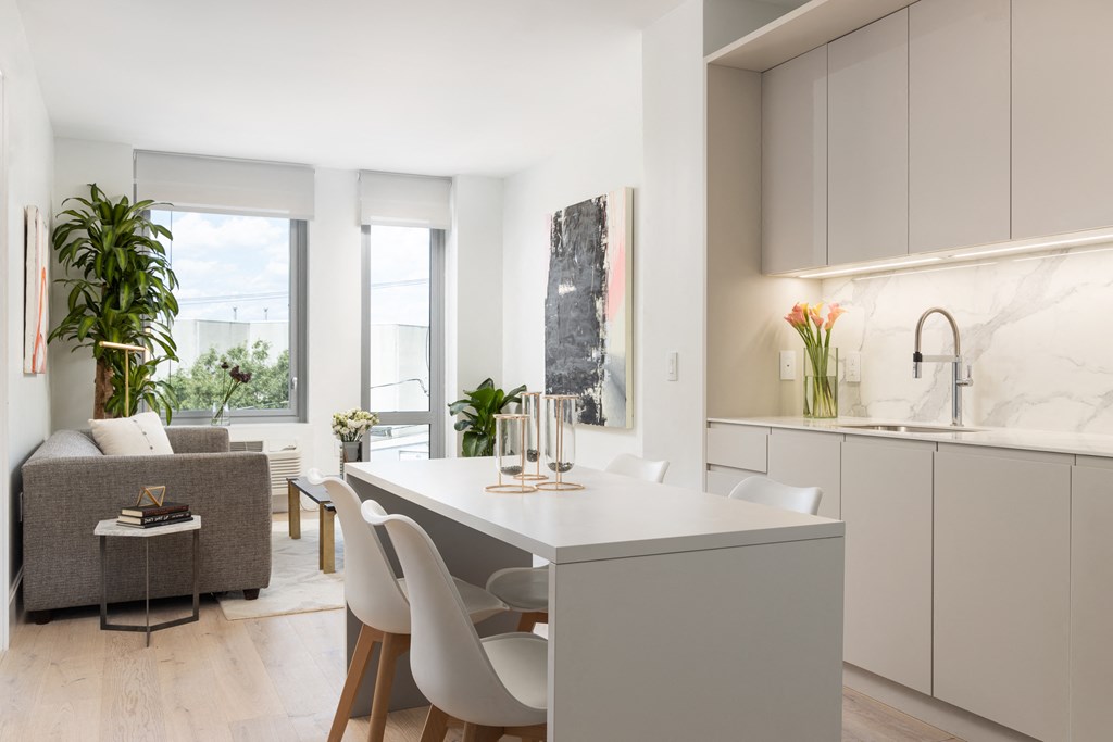 a kitchen and living room with a white table and chairs
