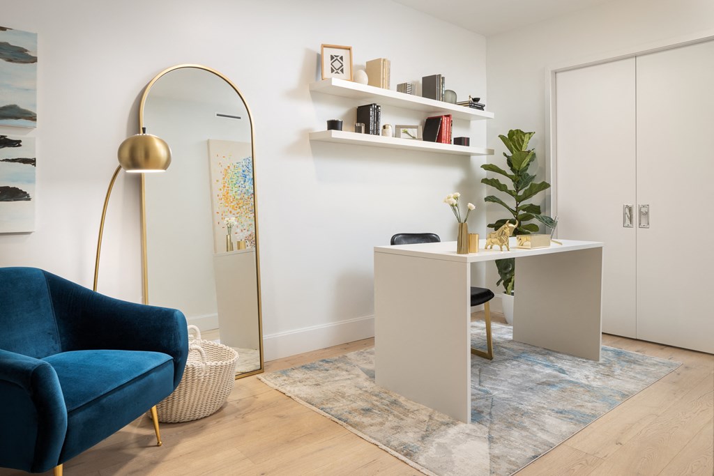 a living room with a white desk and a blue chair