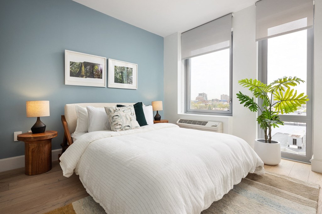 a bedroom with a bed and two windows