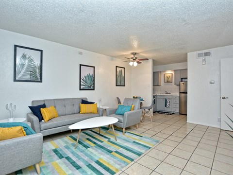 A living room with a grey couch and a white coffee table.