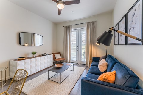 A living room with a blue couch and a gold chair.