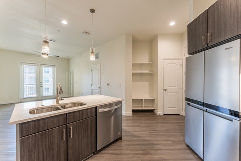 A kitchen with a white counter top and stainless steel appliances.