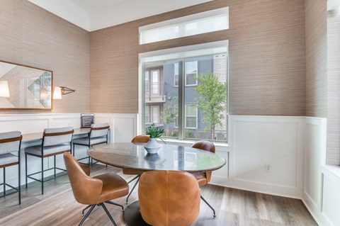 A dining room with a table and chairs.